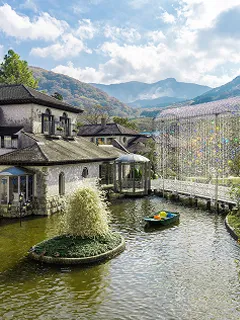 水辺に建つ宿泊施設の外観、池に映る建物と山並み