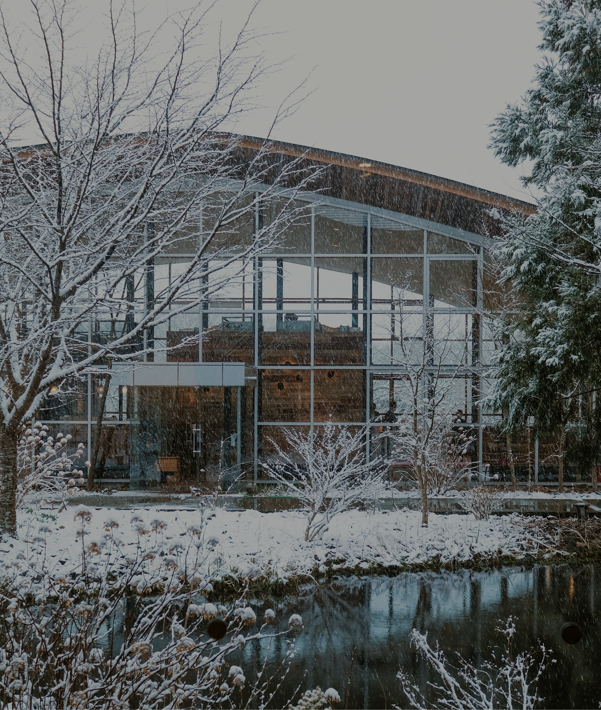 雪化粧をまとった建物と庭園、冬景色のガラス張りの建物